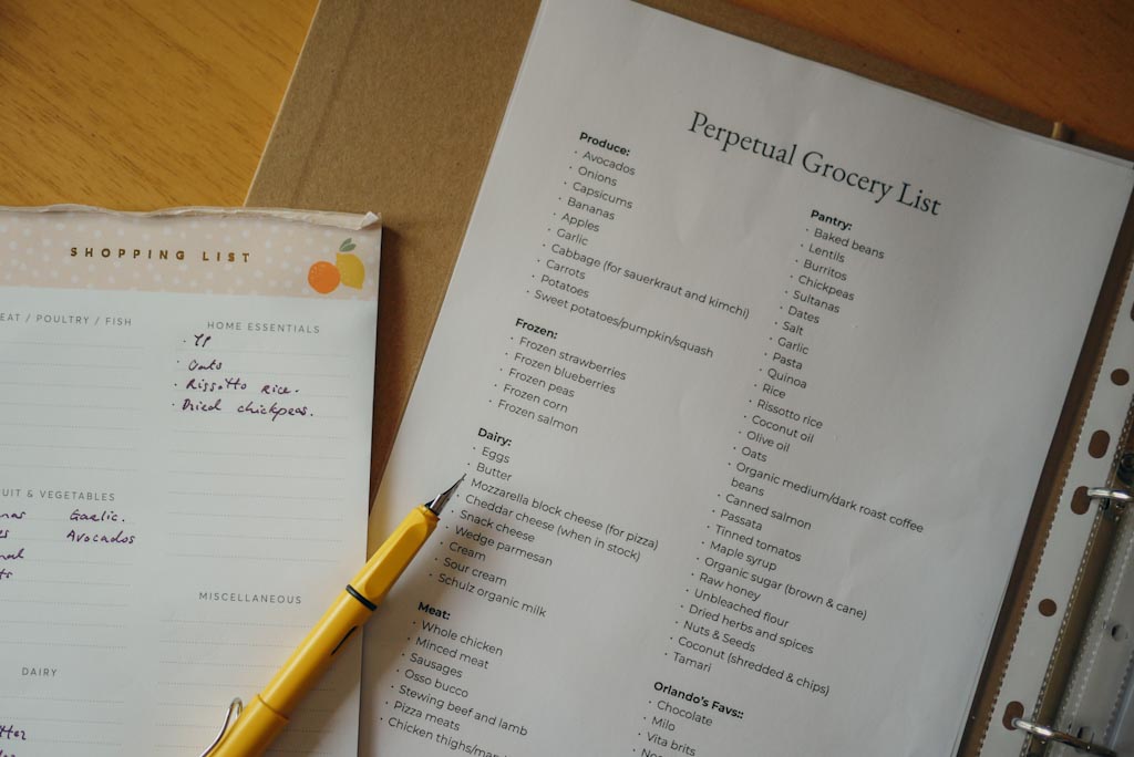 An image of a yellow fountain pen and shopping list pad with a printed perpetual shopping list to help making weekly grocery shopping easier.  