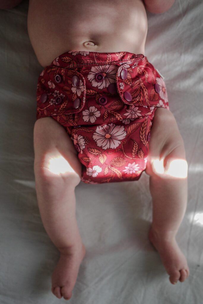 Newborn in cloth nappy with pink and red design